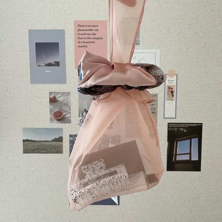 ピンク色のミニバッグと感性的なウォールデコが調和するこぢんまりとした空間