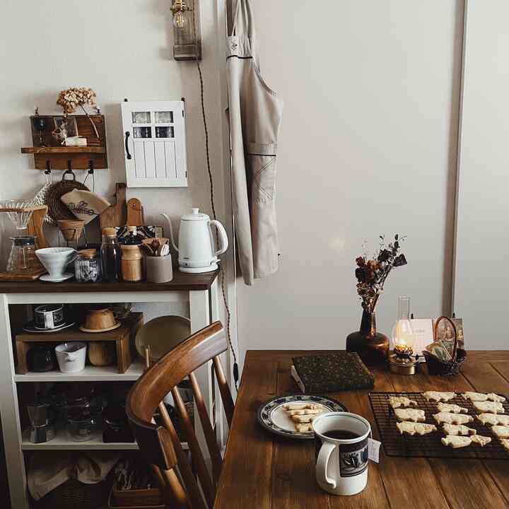 ナチュラルな木目調と白を基調としたダイニング、おしゃれなコーヒー道具とお菓子が置かれた雰囲気のあるおうちカフェ空間