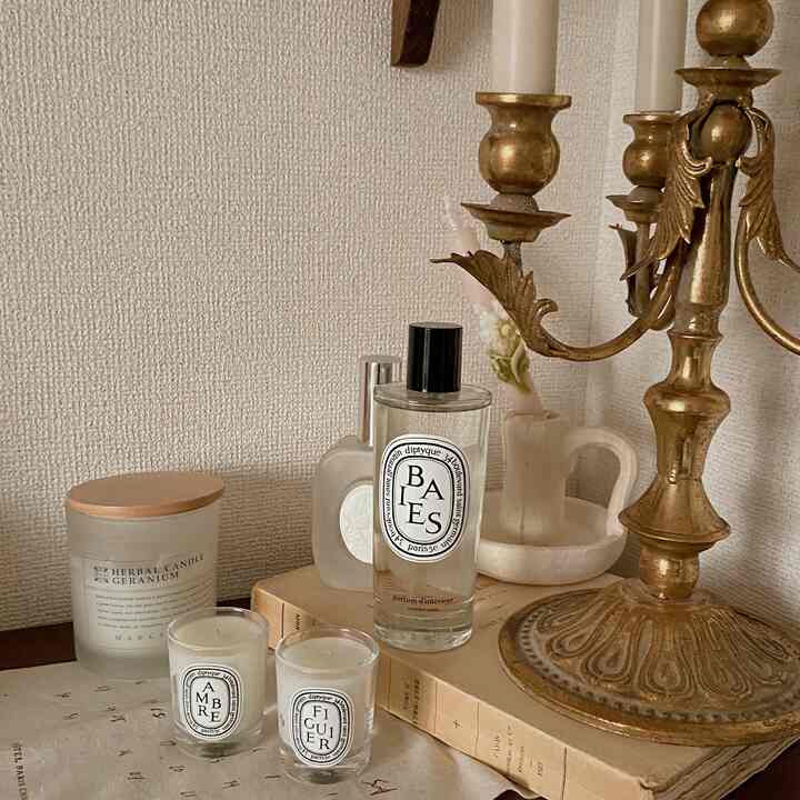 暖かいベージュとゴールドのトーンが映えるリビング、ミニキャンドルとディフューザーが配置された落ち着いた雰囲気のインテリア