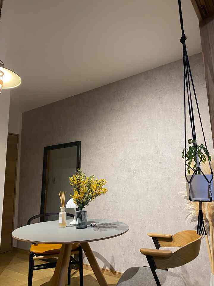 Gray-walled dining room with wood-tone furniture in Nordic style, featuring a simple and cozy atmosphere