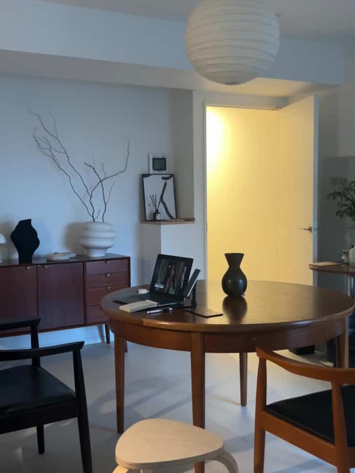 木目調と白が調和したダイニング、丸いテーブルとアームチェアが配置された自然な雰囲気のインテリア