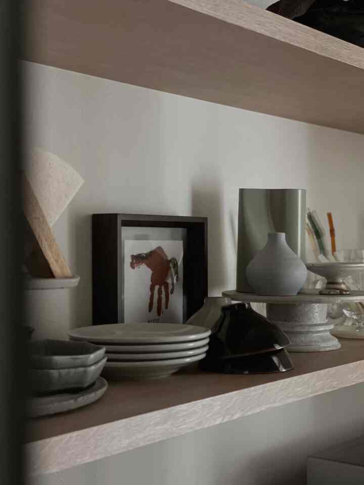 ベージュの木目調棚に和食器や皿が並ぶ自然な雰囲気のキッチンインテリア