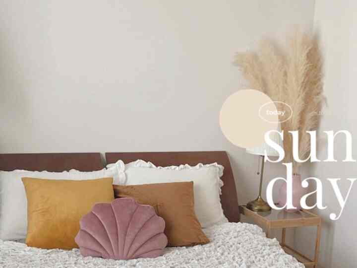 ホワイトを基調とし、オレンジとピンクの差し色がある6畳の二人用寝室、シンプルで温かみのある印象のインテリア