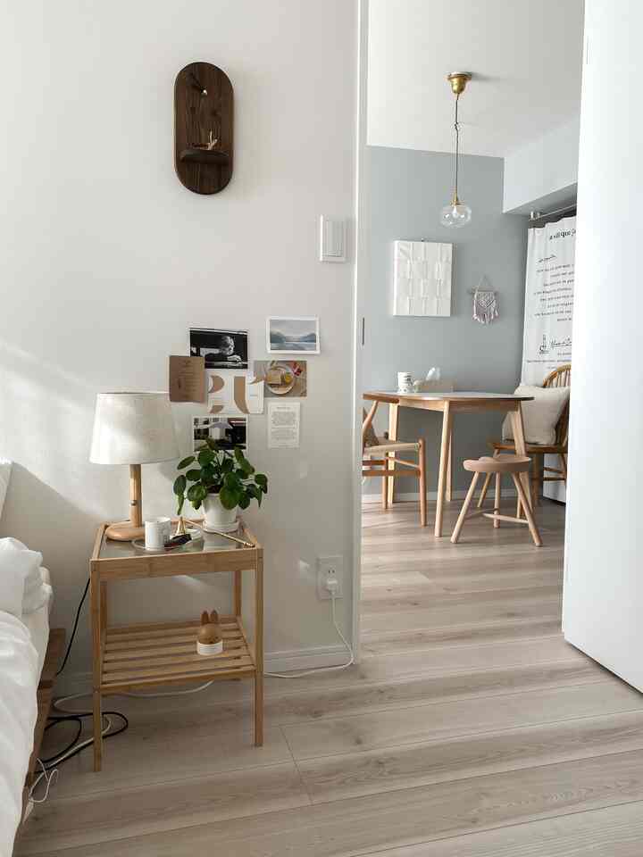 白い壁と木目調家具を配したナチュラルな寝室とダイニングスペース