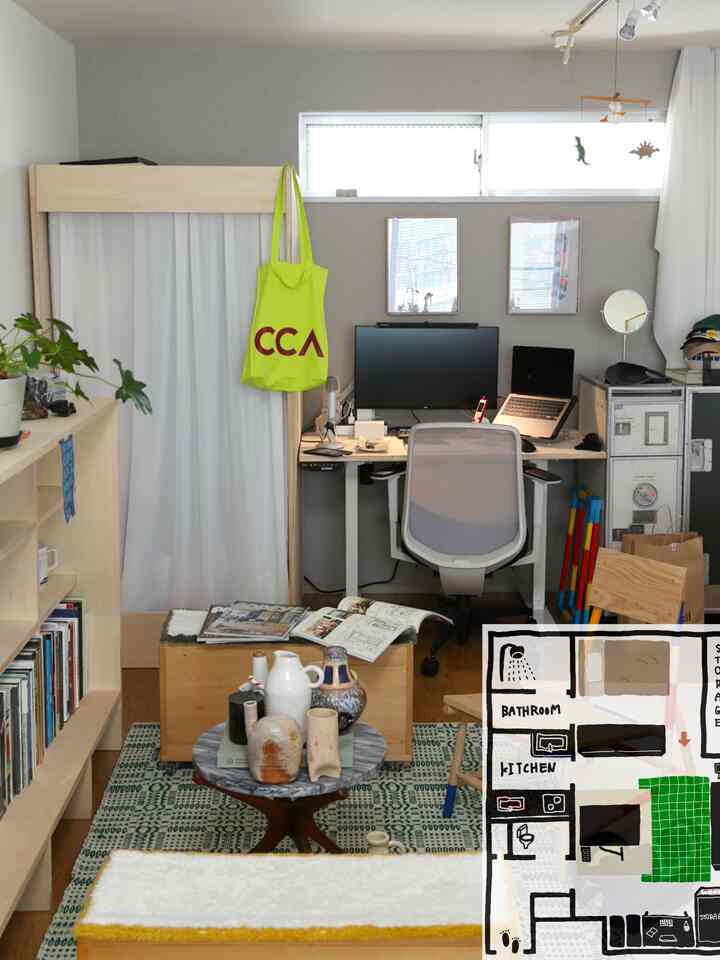 明るく自然な色調のワンルーム、オフィスデスクとチェア、本棚、木製の小物が配置されたシンプルなホームオフィスのあるインテリア