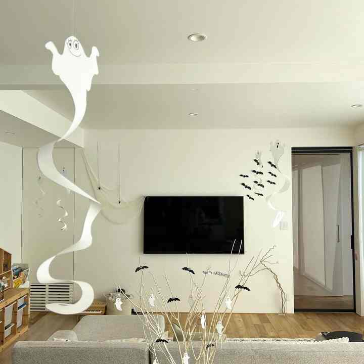 白と茶色を基調としたリビング、ゴーストとコウモリの飾りが置かれた印象的なホームパーティーの空間