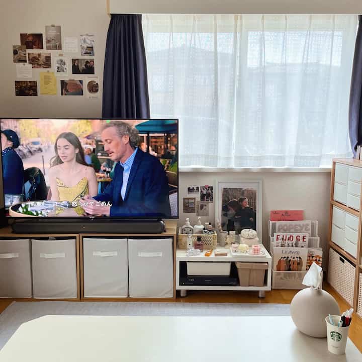 白とベージュのトーンのリビング、テレビ台とコーヒーテーブルが配置されたシンプルで整った収納アイデアのある印象的な空間