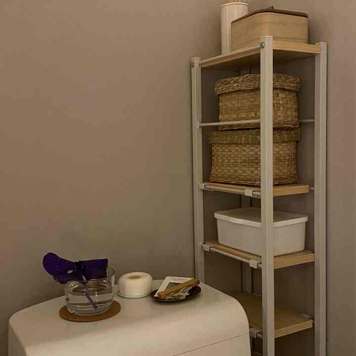 Beige-toned walls with white storage shelves and bathroom accessories in a clean bathroom space