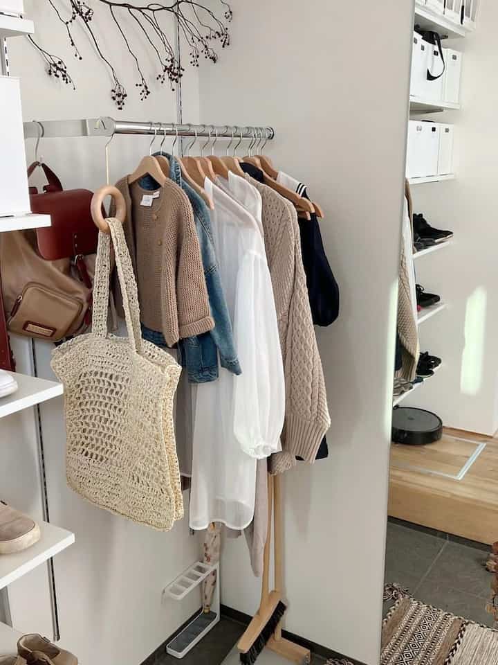 白と茶色の落ち着いた玄関横のクローゼット空間、収納アイデアが活かされたモダンで自然な雰囲気のインテリア