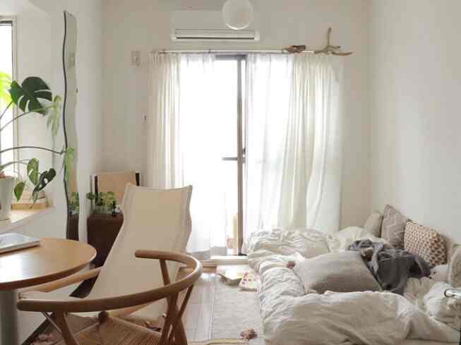 白とナチュラルカラーのダイニング兼ホームオフィスが配置された、落ち着いた一人暮らしの空間