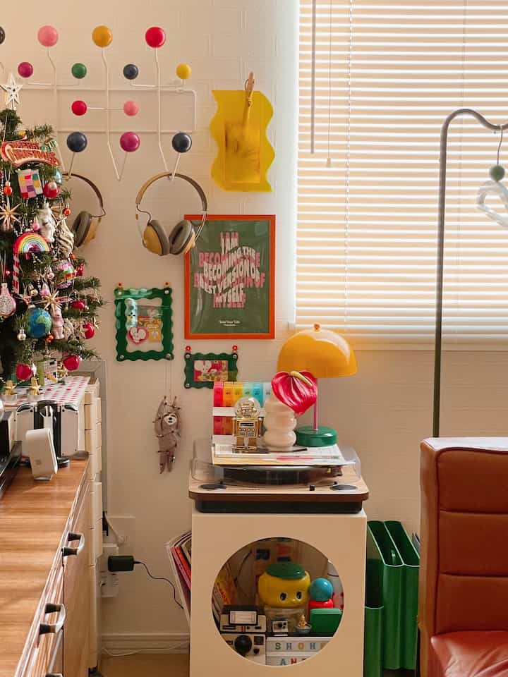 明るいイエローとレッドのアクセントが映えるリビングの一角、レトロなミッドセンチュリーモダンの小物とサイドテーブルが配置された空間