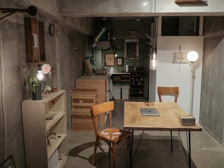 露出したコンクリートの壁と自然な木製家具が調和したモダンインダストリアルのホームオフィス空間です。