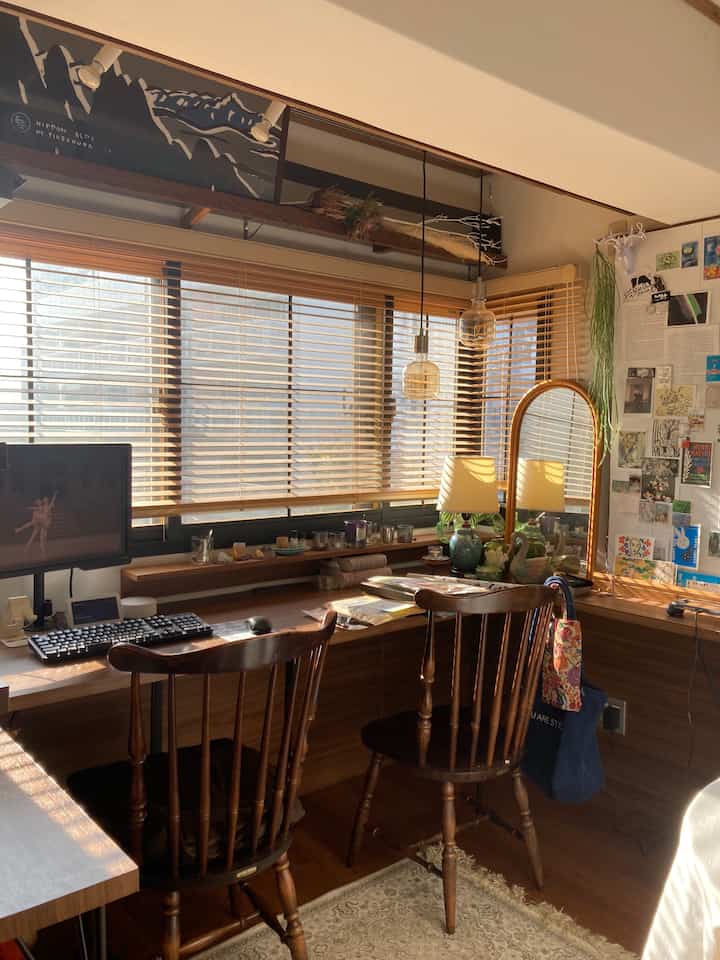 暖かみのあるブラウン調のワークスペース、L字型の木製デスクと椅子が配置された自然な雰囲気の空間