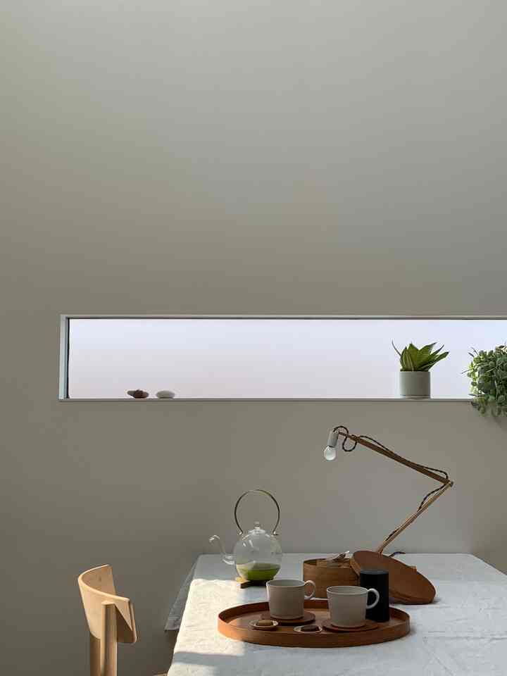 ナチュラルな色調のキッチン、木製トレイとカップが配置されたミニマルで心地よい雰囲気のインテリア