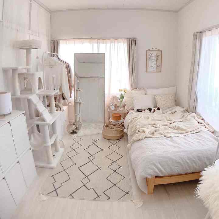 Ivory-toned small bedroom featuring a bed and cat tower arranged neatly with a calm atmosphere