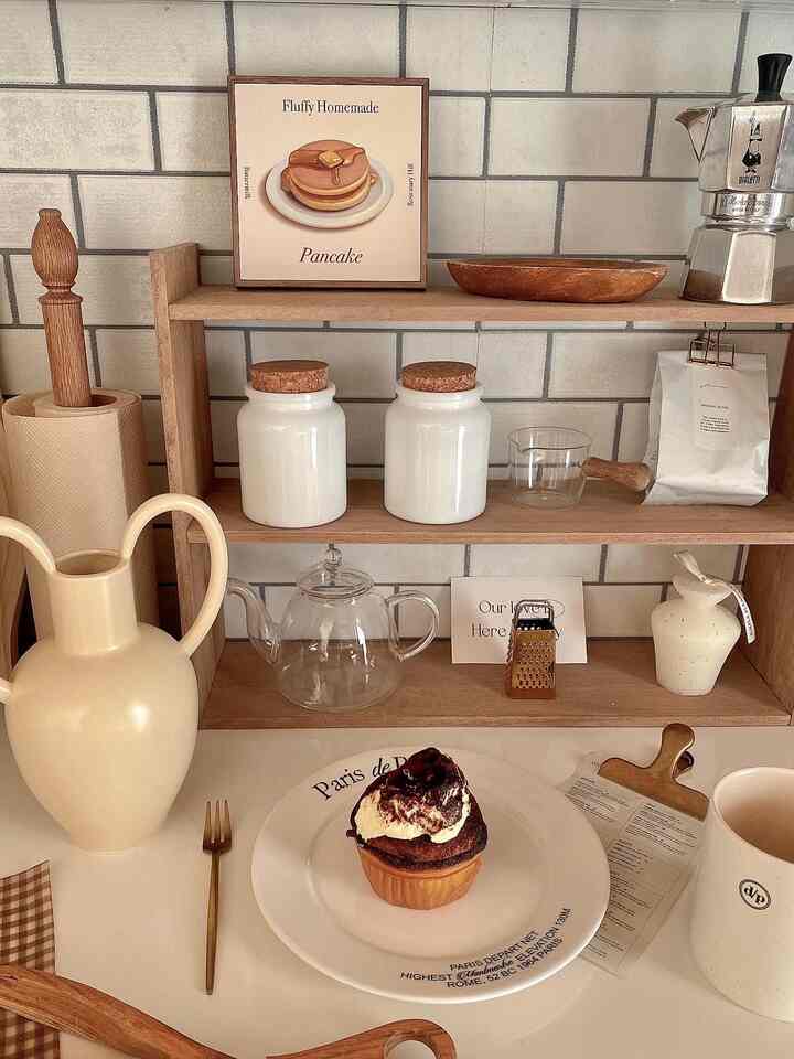 ベージュとナチュラルな色調のキッチン、木製の棚とコーヒー用品が配置された雰囲気のあるおうちカフェ