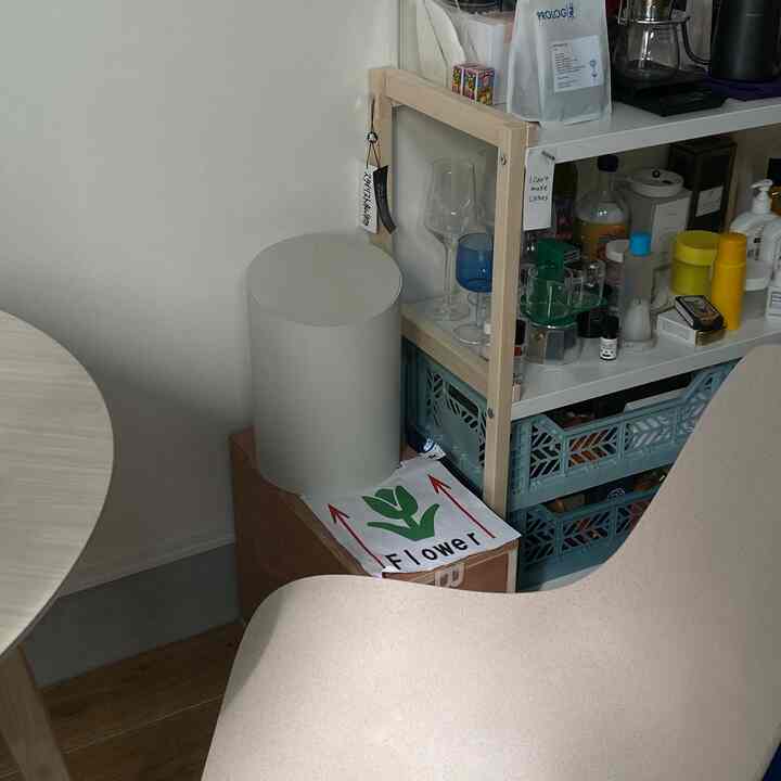 白とナチュラルウッドトーンの調和が感じられるキッチン、丸いダイニングテーブルとベージュのダイニングチェアが配置された雰囲気のあるインテリア