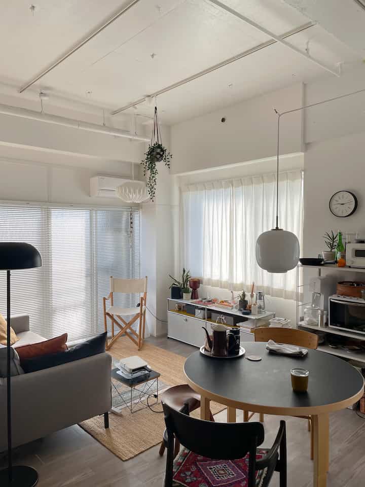 Natural and white toned living and dining room featuring director's chair and round table creating a cozy atmosphere