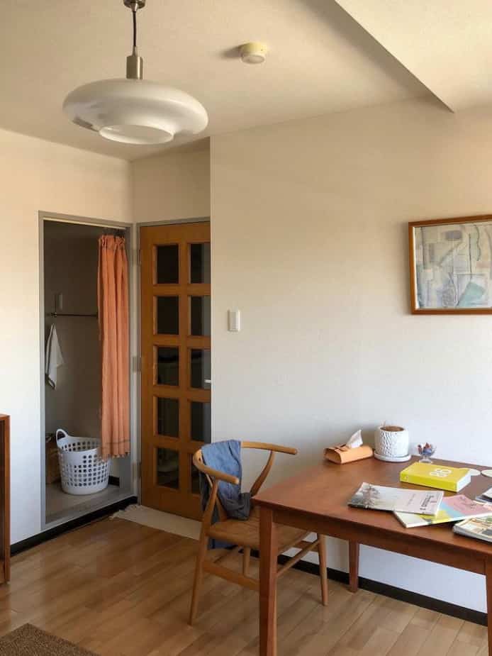 淡いベージュと木目調の調和が感じられるダイニング、シンプルでナチュラルな雰囲気の木製テーブルと椅子が配置された落ち着いた空間