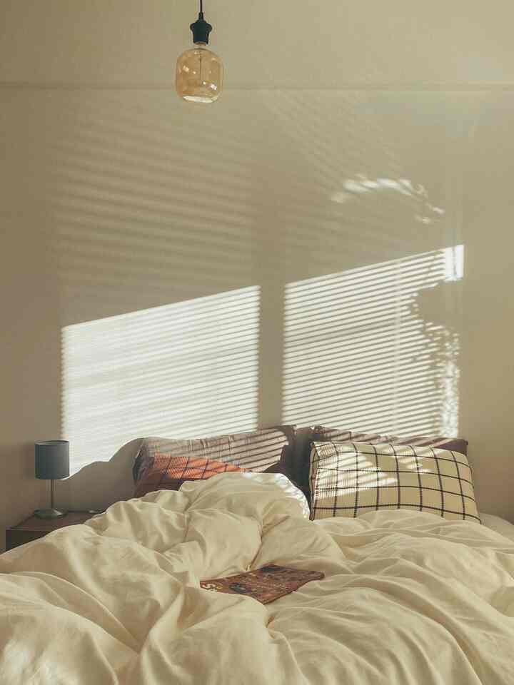 暖かな自然光と白を基調とした寝具が映える1LDK寝室、落ち着いた雰囲気のインテリア