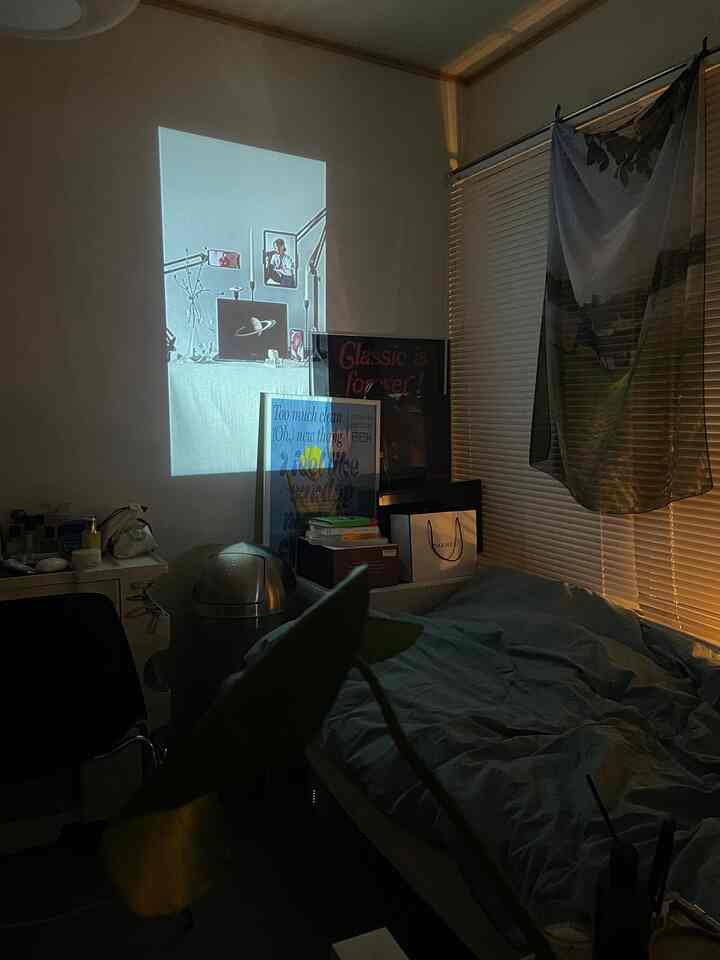 黒とベージュのトーンの小さな寝室、ベッドとポスターが配置された雰囲気のある空間