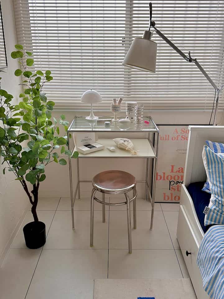 Bright white-tone compact room featuring a modular stainless vanity and stainless round stool with a clean modern vibe