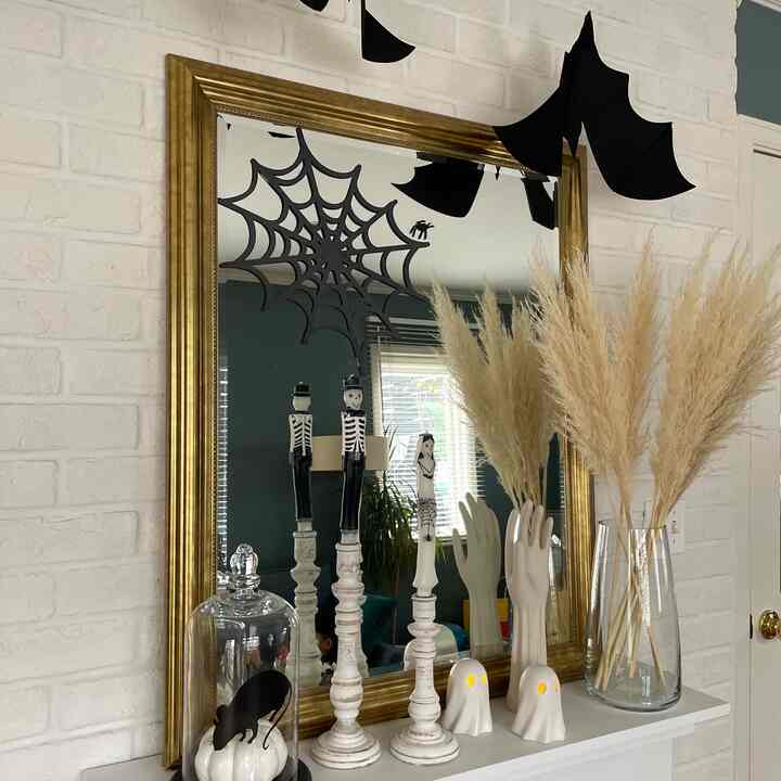 白い壁とゴールドの鏡枠のリビング、パンパスグラスとハロウィン装飾が調和した雰囲気のあるインテリア