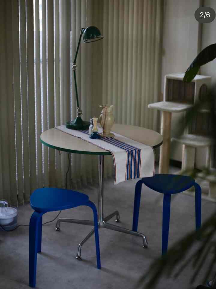 ブルーとホワイトの色調のリビングルーム、丸テーブルとスツール、キャットタワーが配置された落ち着いた雰囲気のインテリア