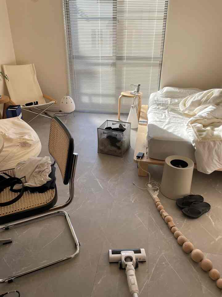 Natural tone small bedroom featuring white and wood tones, minimalist furniture, and soft natural light