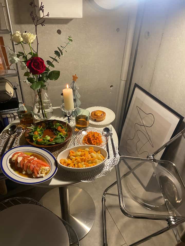 Cozy home cafe dining space with various plates on a white table and a transparent chair