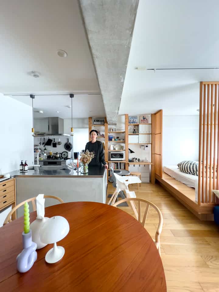 White and brown toned apartment kitchen and dining room featuring natural wood furniture and a modern layout