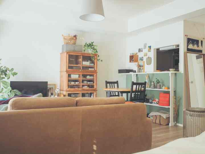 ナチュラルトーンの1LDKリビング、ブラウンソファと木製ダイニングテーブルが配置された温かみのある空間