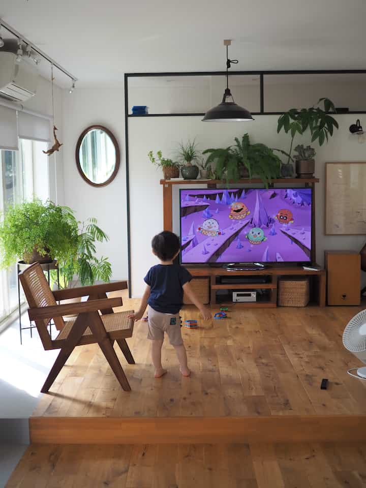 温かみのあるナチュラルな色調のリビング、子供とともに過ごす家族の空間でペンダントライトとラタンバスケットが配置された印象的なインテリア