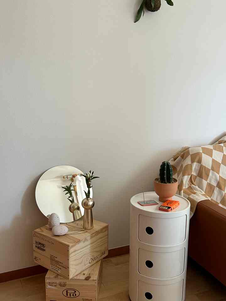 ナチュラルカラーと木目調の1LDKリビング、ブラウンのソファと白い3段チェストが配置された落ち着いた空間