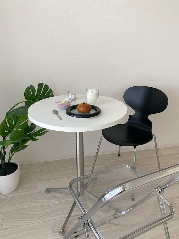 白と黒のカフェ風の小空間、丸テーブルと植物が配置された落ち着いたインテリア