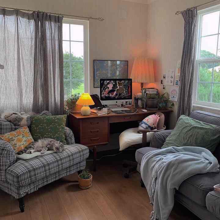 Natural-toned living room featuring checkered sofas, wooden desk, and warm table lamps creating a cozy atmosphere