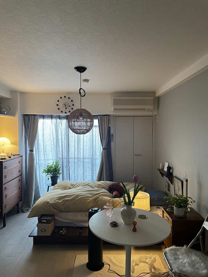 Natural modern bedroom with bed, wood tone furniture, and plants creating a cozy atmosphere