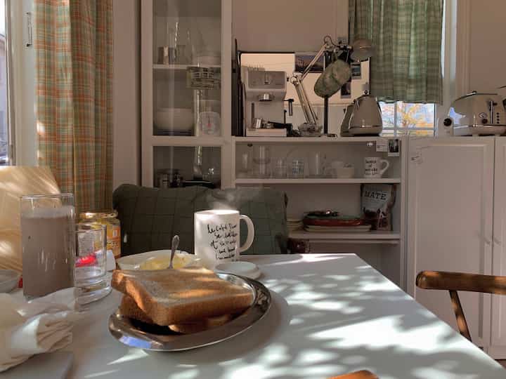 白と緑の色調のダイニング、コーヒーマシンと朝食が配置された雰囲気のあるおうちカフェ空間