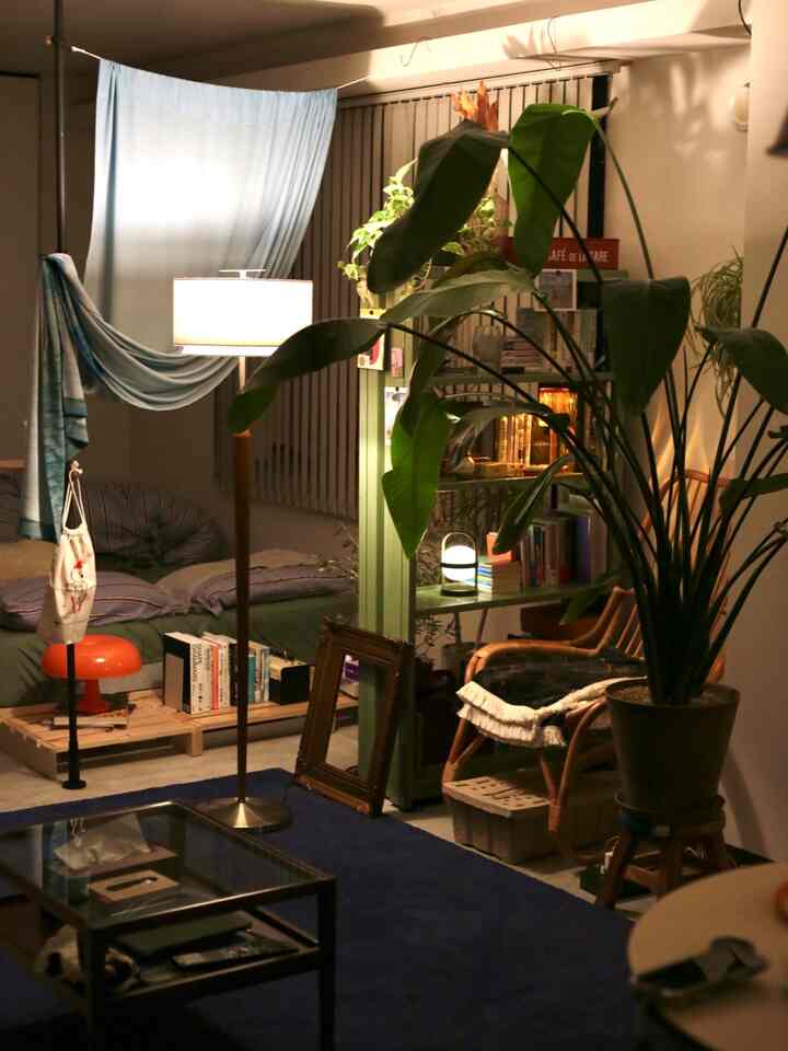 Light gray walled living room with navy rug, featuring an armchair and floor lamp in a calm, natural setting