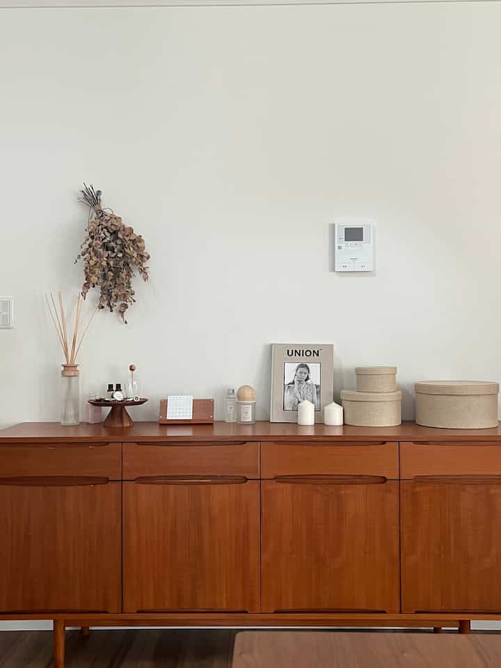 Natural brown-toned cabinet with minimalist decor items placed in a clean and simple living space