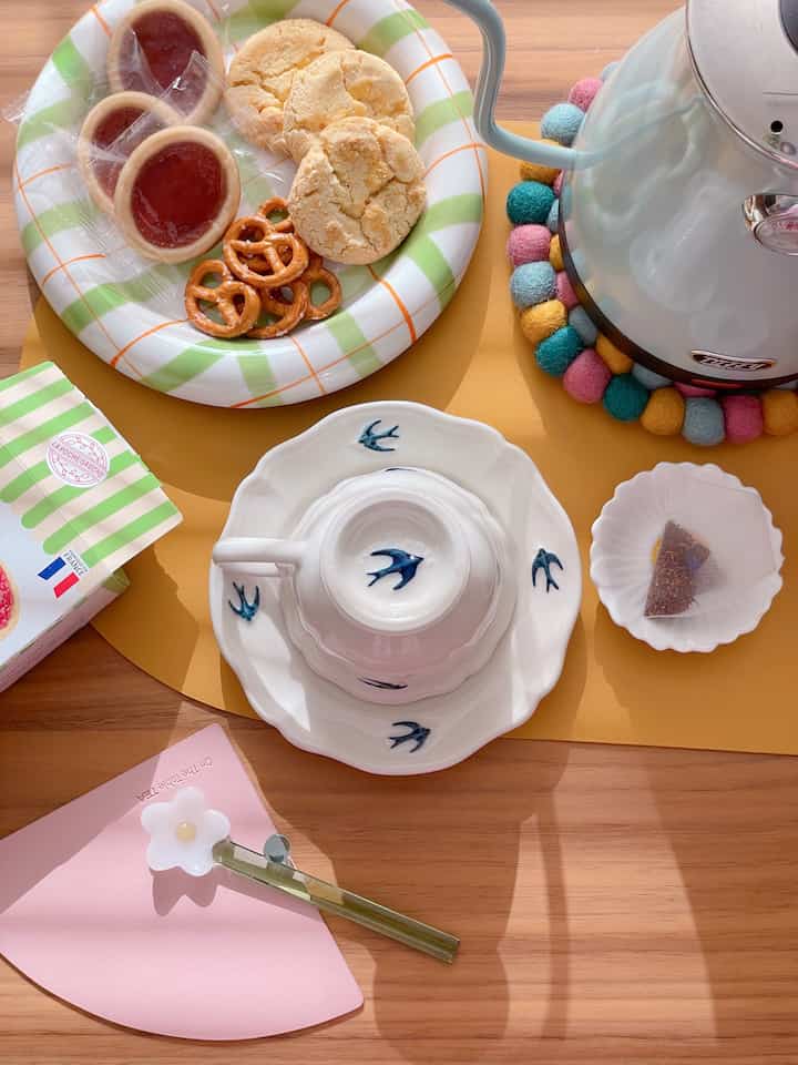 White and wood tone home cafe setting featuring charming tea time items on a warm wooden table