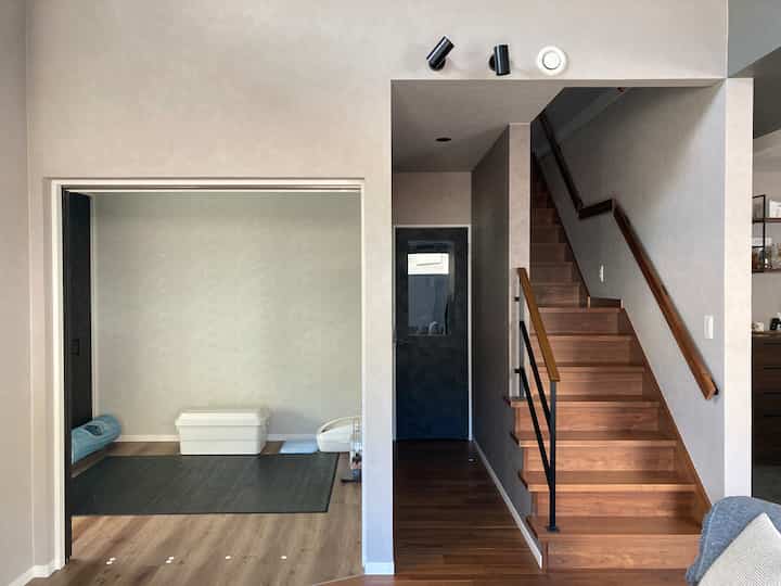 Natural interior with beige and brown tones featuring a compact cat area and wooden staircase