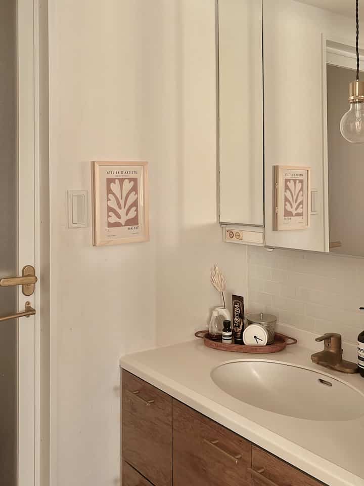 Natural-toned bathroom featuring wood tone cabinet and white washbasin with a simple, clean design