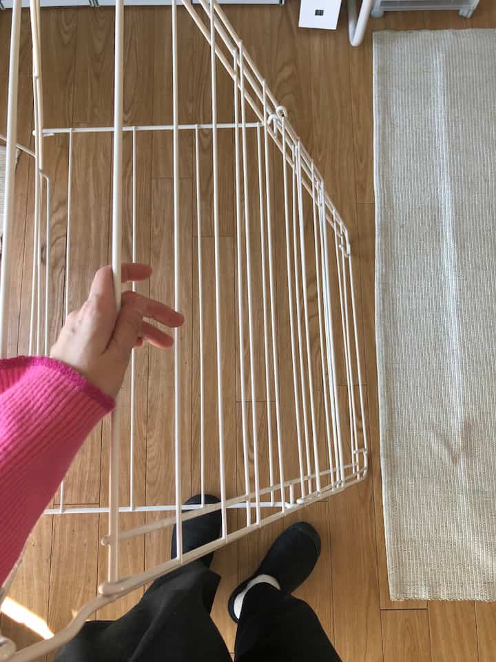 ナチュラルな木目調の床と白いIKEAの室内物干しラックがあるコンパクトな室内