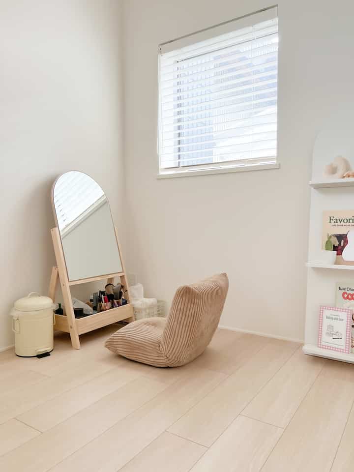 ベージュとアイボリーの色調の小さなドレッサールーム、コーデュロイの座椅子と姿見が配置された落ち着いた雰囲気のインテリア