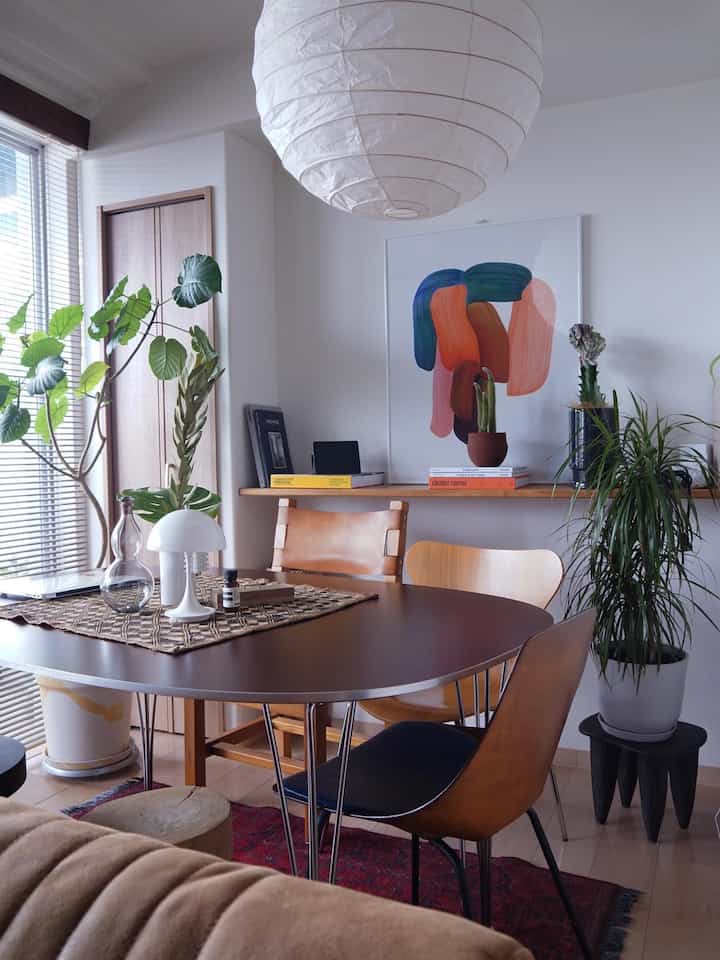 白と茶色を基調とした二人暮らしのダイニングルーム、植物とヴィンテージ家具が配置された雰囲気のあるナチュラルモダンな空間