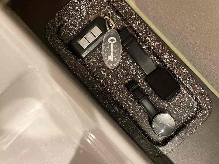 ブラウンのトレイに鍵と腕時計が整頓された玄関の清潔な空間