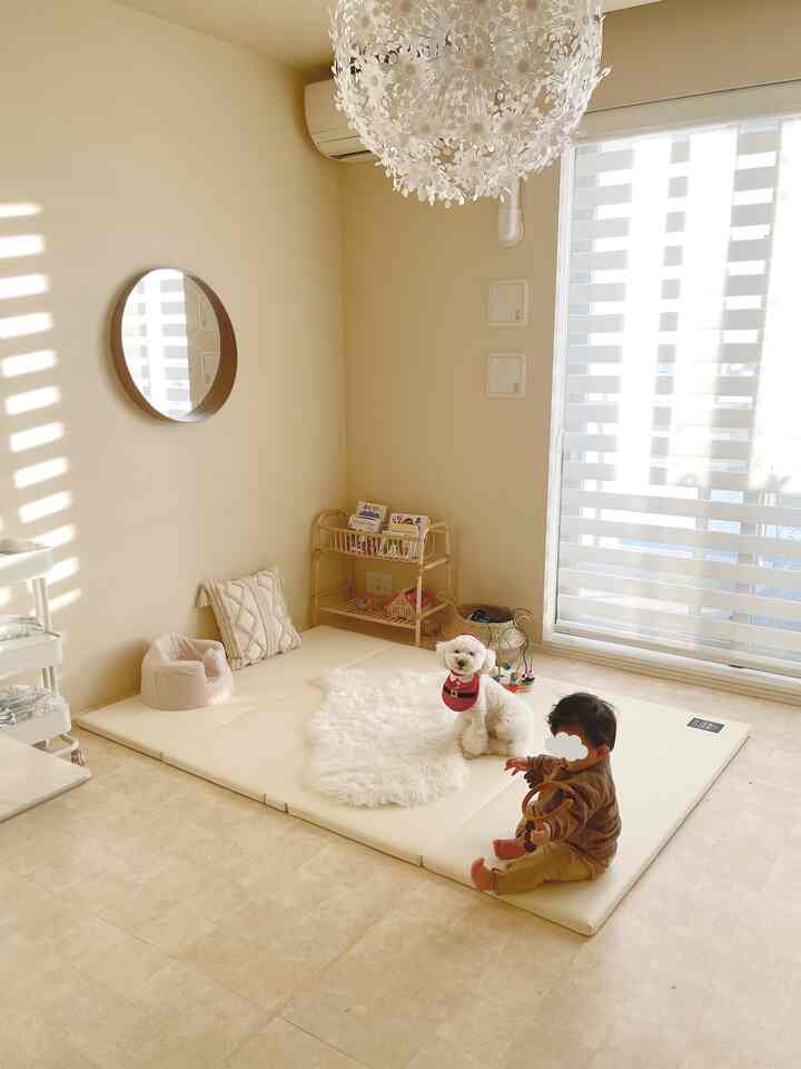 Beige natural-toned living space featuring a child and dog sitting on a foldable play mat with a cozy, simple atmosphere