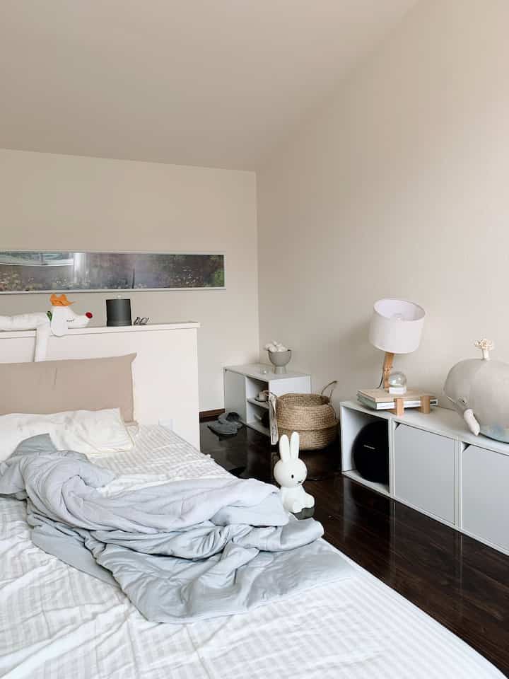 White and blue-gray toned bedroom featuring minimal and natural furniture and accessories with a cozy atmosphere