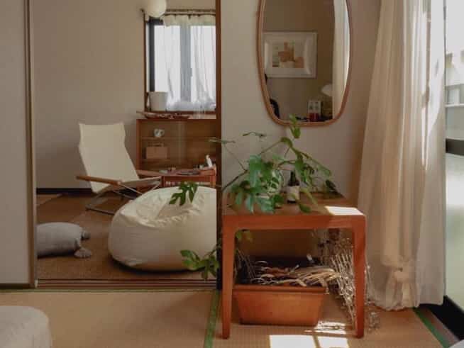 ベージュと木目調のリビング、ビーズクッションとアームチェアが配置された自然な雰囲気のあるインテリア